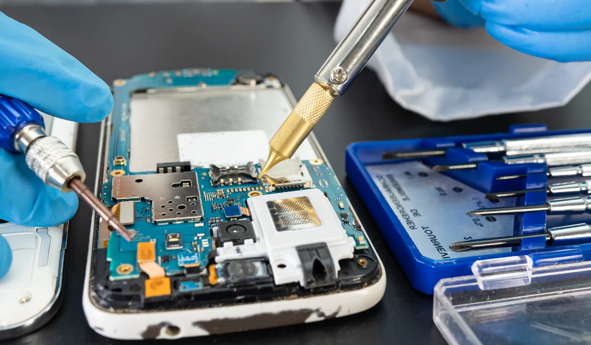 Technicien révisant un ordinateur portable dans un atelier, illustrant le processus de reconditionnement